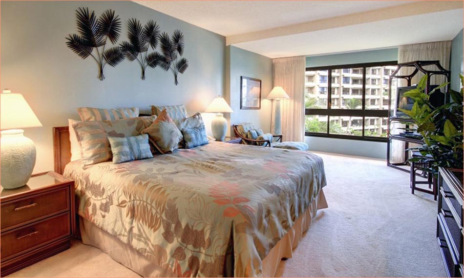 The king sized master bedroom features a personal TV, entertainment center, and views of the Kaanapali gardens.
